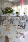 Оформление гостевых столов композициями с использованием декоративной флористики и живой зелени на высокой стойке