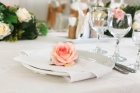 Оформление сервировочных тарелок на гостевых столах бутонами из декоративной флористики
